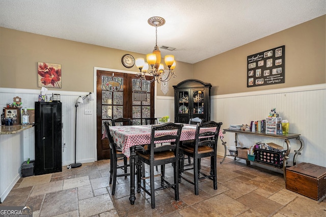 dining area featuring a textured ceiling and a notable chandelier