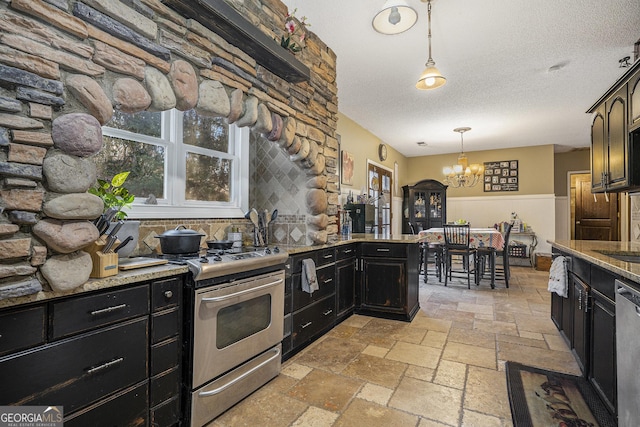 kitchen with appliances with stainless steel finishes, decorative light fixtures, light stone countertops, a textured ceiling, and an inviting chandelier