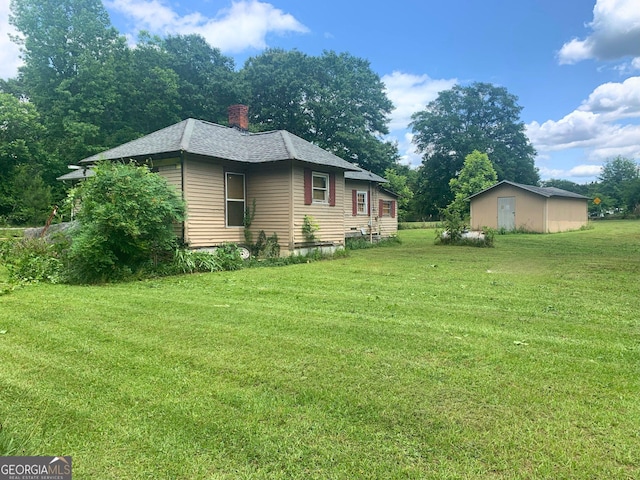 view of home's exterior with a lawn and a storage shed