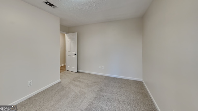 carpeted spare room featuring a textured ceiling