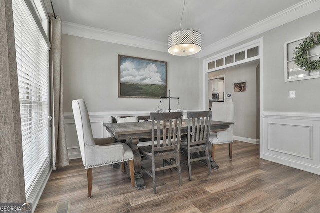 dining room with dark wood-type flooring and ornamental molding