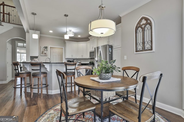 dining room featuring ornamental molding and dark hardwood / wood-style floors