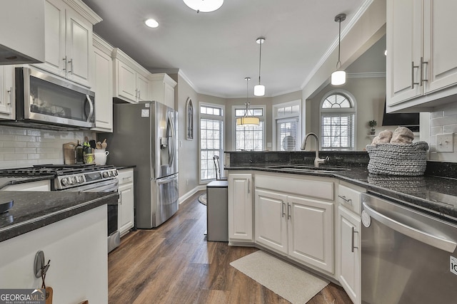 kitchen with dark hardwood / wood-style floors, sink, hanging light fixtures, stainless steel appliances, and white cabinets