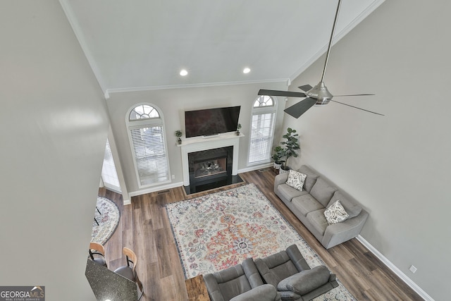 living room featuring ceiling fan, dark wood-type flooring, and crown molding