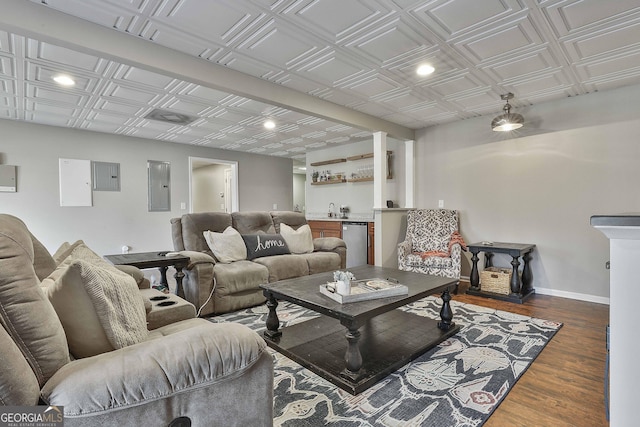 living room with indoor wet bar, dark wood-type flooring, and electric panel