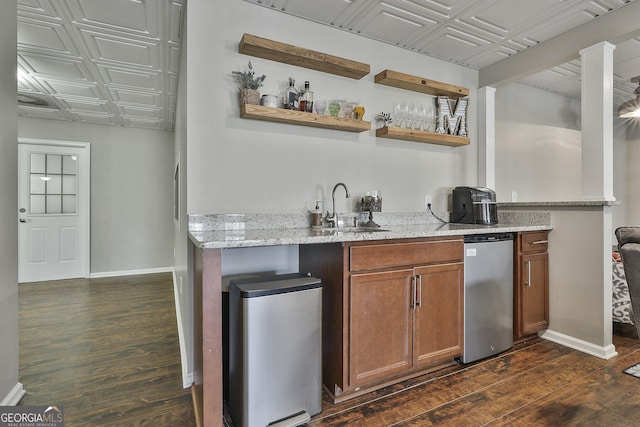 bar featuring light stone counters, sink, and dark hardwood / wood-style floors