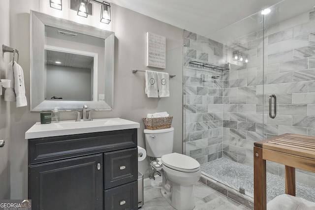 bathroom featuring a shower with shower door, toilet, and vanity