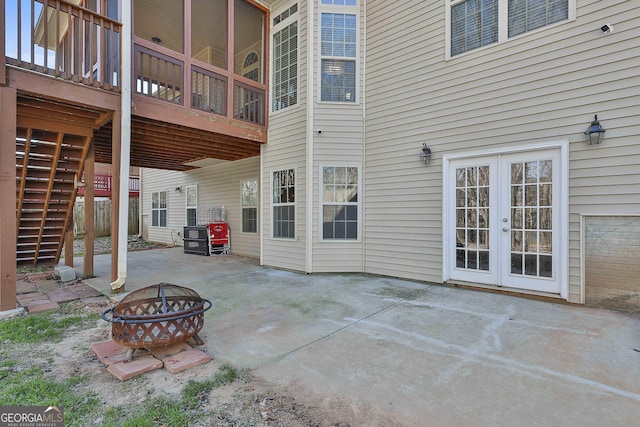 view of patio / terrace with an outdoor fire pit, french doors, and a wooden deck