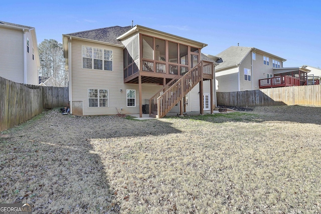 rear view of property with a sunroom and a yard