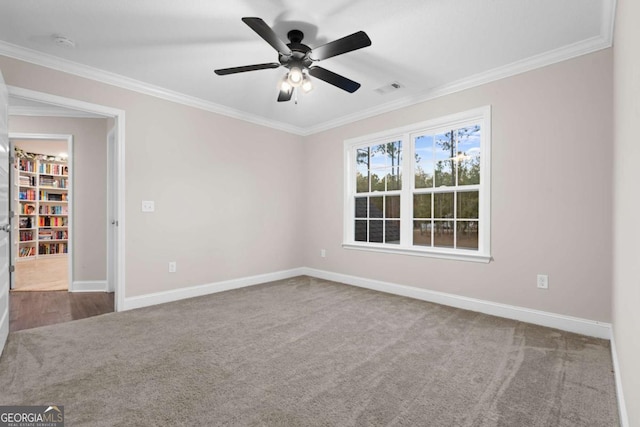 spare room featuring carpet, ceiling fan, and crown molding