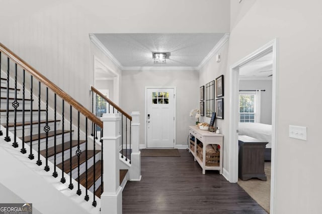 entrance foyer with dark hardwood / wood-style floors, ornamental molding, and a textured ceiling