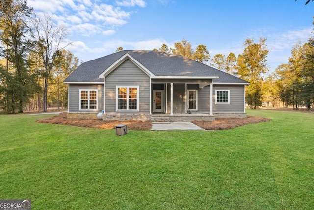 rear view of property featuring a lawn