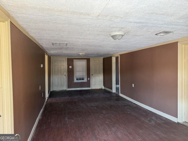 unfurnished room with a textured ceiling and dark hardwood / wood-style floors