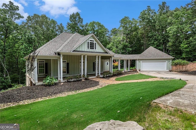 view of front of house featuring a porch, a front yard, and a garage