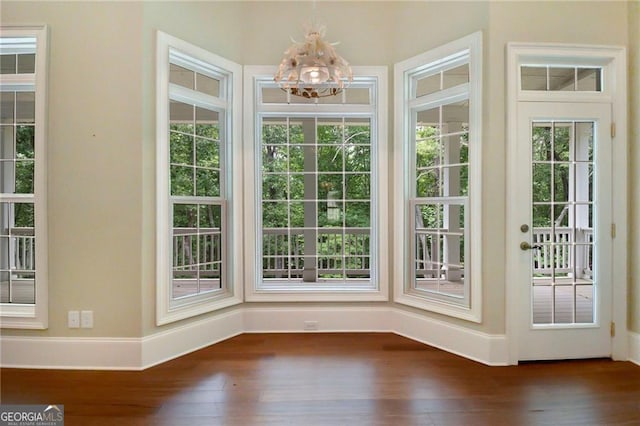 doorway with dark hardwood / wood-style flooring and a chandelier