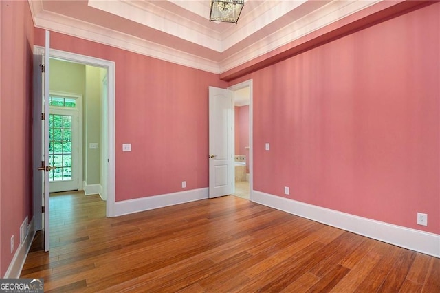 unfurnished room featuring hardwood / wood-style flooring, a raised ceiling, and a chandelier