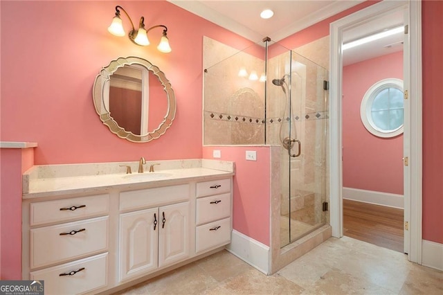 bathroom with vanity, an enclosed shower, and crown molding