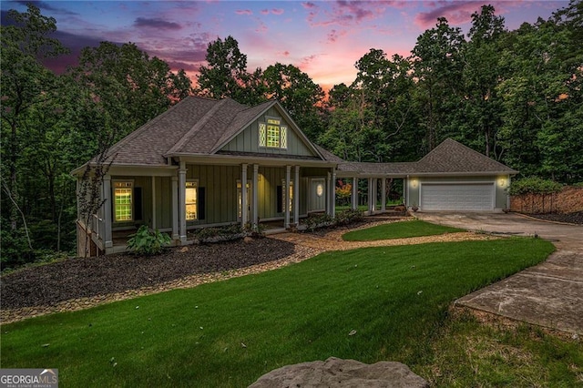 view of front facade with a lawn, a porch, and a garage