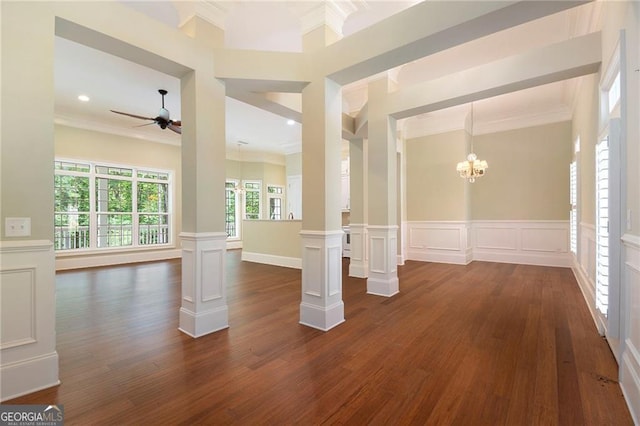 unfurnished room featuring decorative columns, crown molding, dark hardwood / wood-style floors, and ceiling fan with notable chandelier