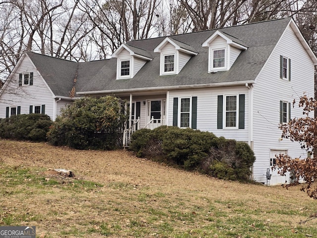 cape cod house with a front yard