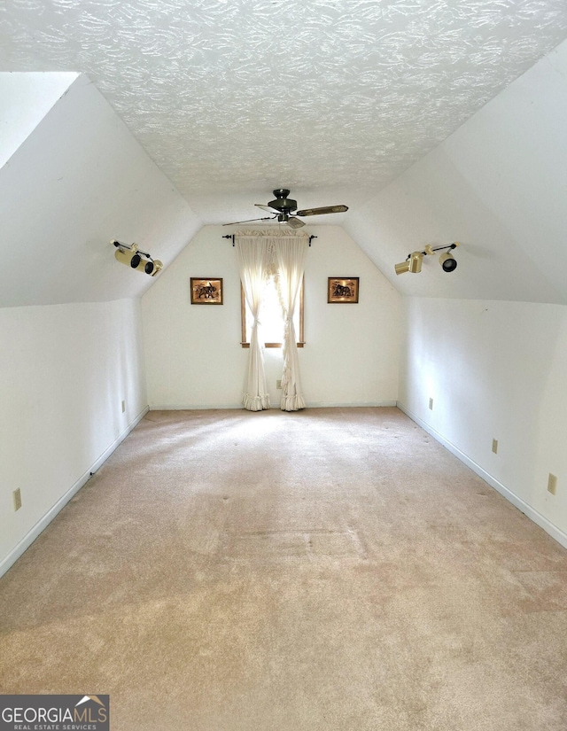 bonus room featuring lofted ceiling, ceiling fan, light carpet, and a textured ceiling