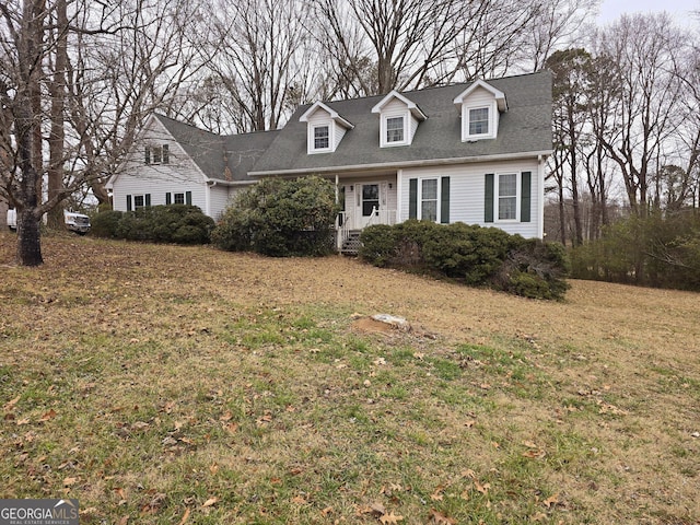 cape cod home with a front lawn