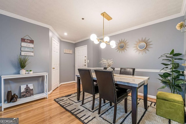 dining room with a chandelier, light hardwood / wood-style flooring, and crown molding