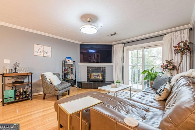 living room with crown molding, wood-type flooring, and a textured ceiling