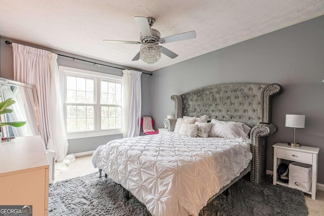 bedroom featuring ceiling fan, carpet floors, and a textured ceiling