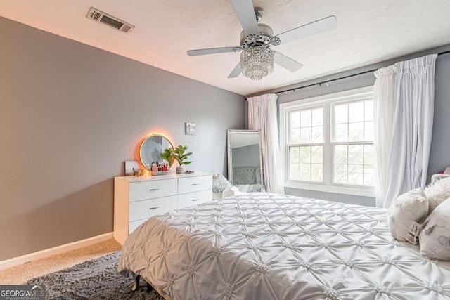 bedroom with ceiling fan, carpet, and a textured ceiling