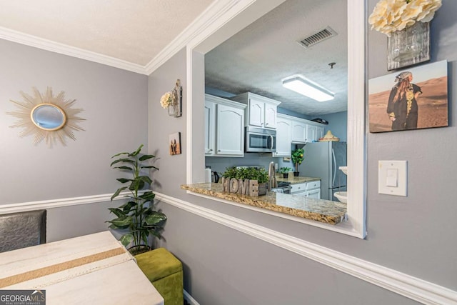 interior space featuring ornamental molding and a textured ceiling