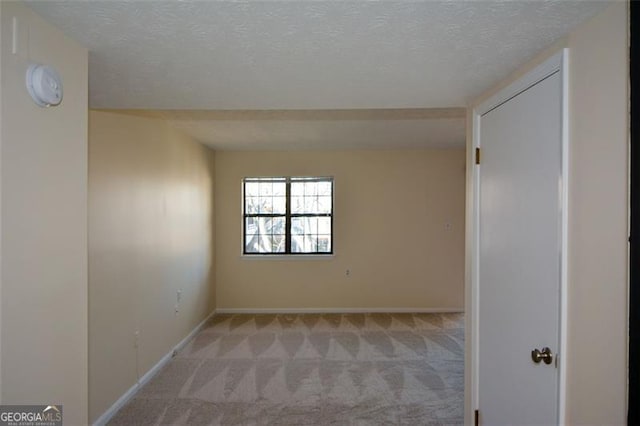 carpeted spare room with a textured ceiling