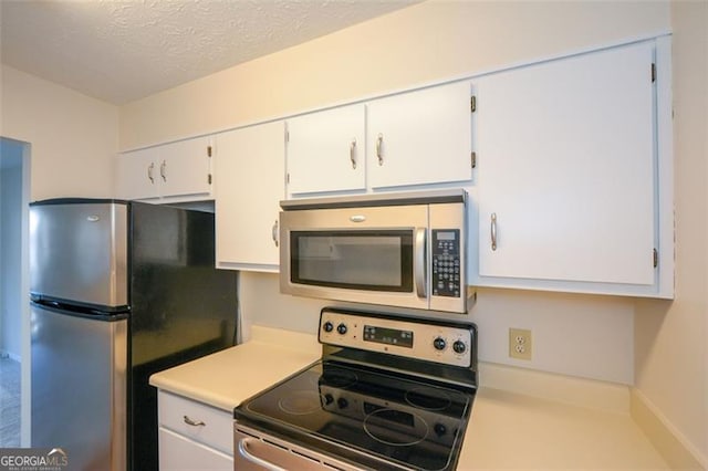 kitchen with appliances with stainless steel finishes, a textured ceiling, and white cabinetry