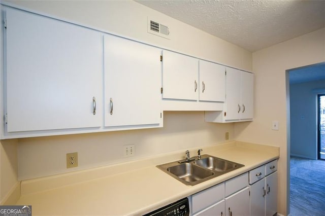 kitchen with white cabinets, a textured ceiling, carpet flooring, and sink