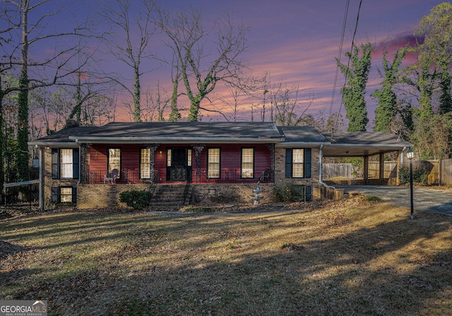 single story home featuring a carport and a yard