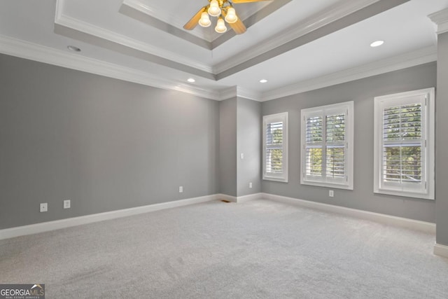 unfurnished room with ceiling fan, crown molding, light carpet, and a tray ceiling