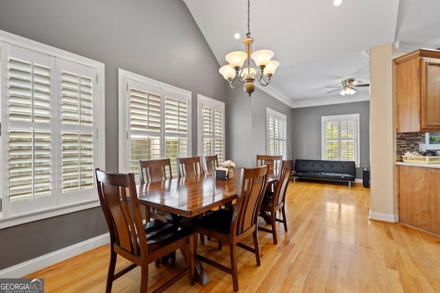 dining room with vaulted ceiling, light hardwood / wood-style floors, and ceiling fan with notable chandelier