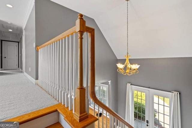 staircase with carpet, an inviting chandelier, a wealth of natural light, and lofted ceiling