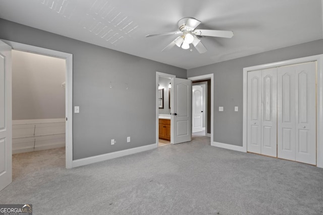 unfurnished bedroom featuring connected bathroom, ceiling fan, a closet, and light carpet