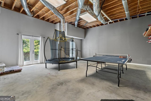 playroom featuring french doors and concrete flooring