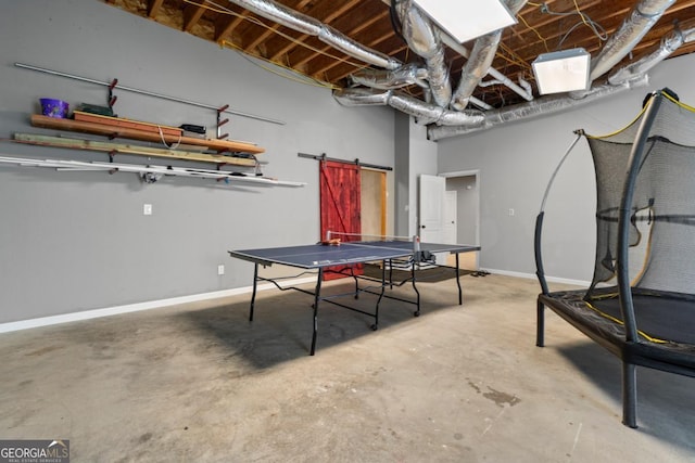 recreation room with concrete floors and a barn door