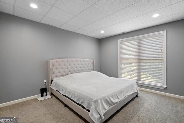 bedroom with a drop ceiling and carpet