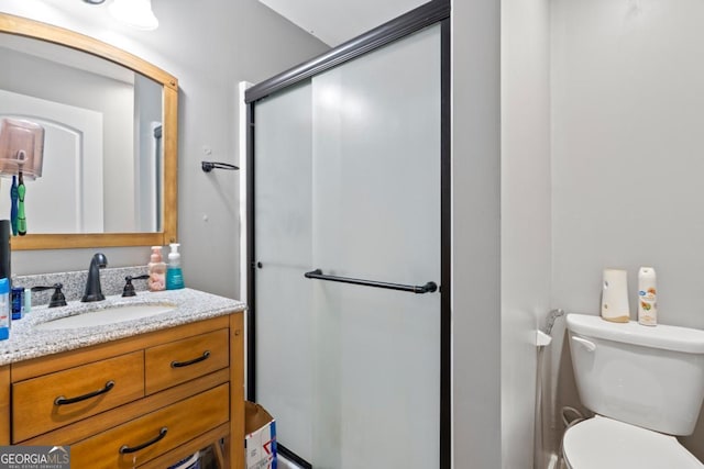 bathroom with toilet, vanity, and walk in shower