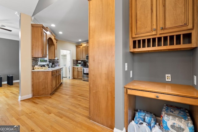 kitchen featuring stove, tasteful backsplash, ceiling fan, crown molding, and light hardwood / wood-style flooring