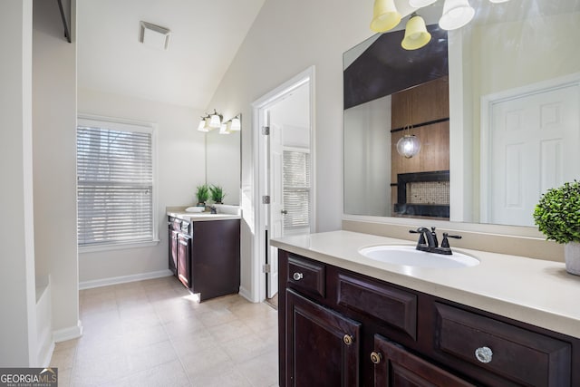 bathroom with vanity and lofted ceiling