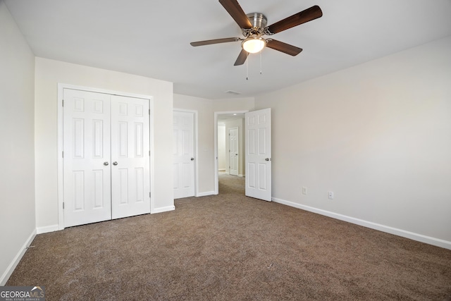 unfurnished bedroom with dark colored carpet, a closet, and ceiling fan