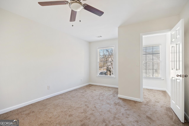 carpeted spare room with ceiling fan