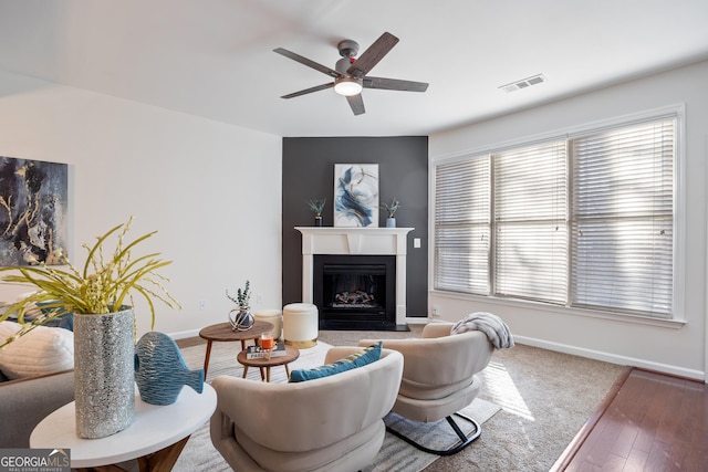 living room with dark hardwood / wood-style flooring, ceiling fan, and plenty of natural light