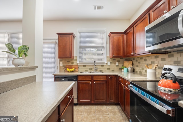 kitchen featuring backsplash, sink, stainless steel appliances, and a wealth of natural light