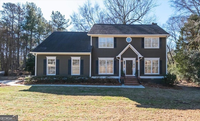 colonial home featuring a front lawn